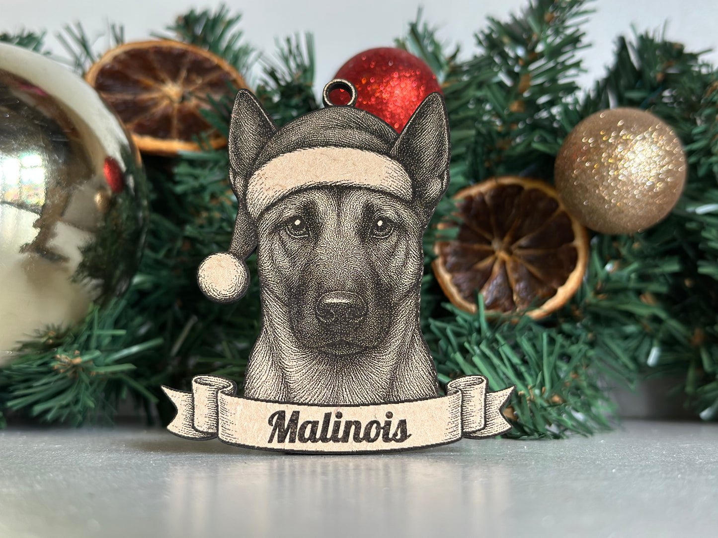 Decorative Christmas ornament with a dog illustration and 'Malinois' text on a banner.