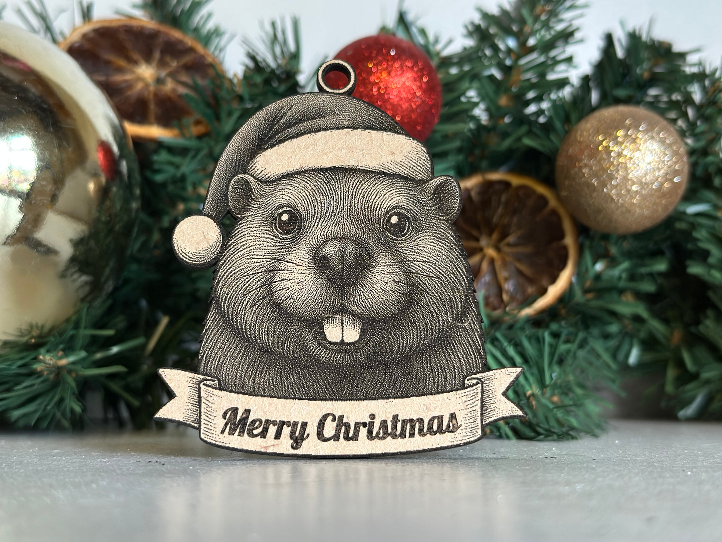 Decorative Christmas ornament with a beaver illustration and 'Merry Christmas' text on a tree.