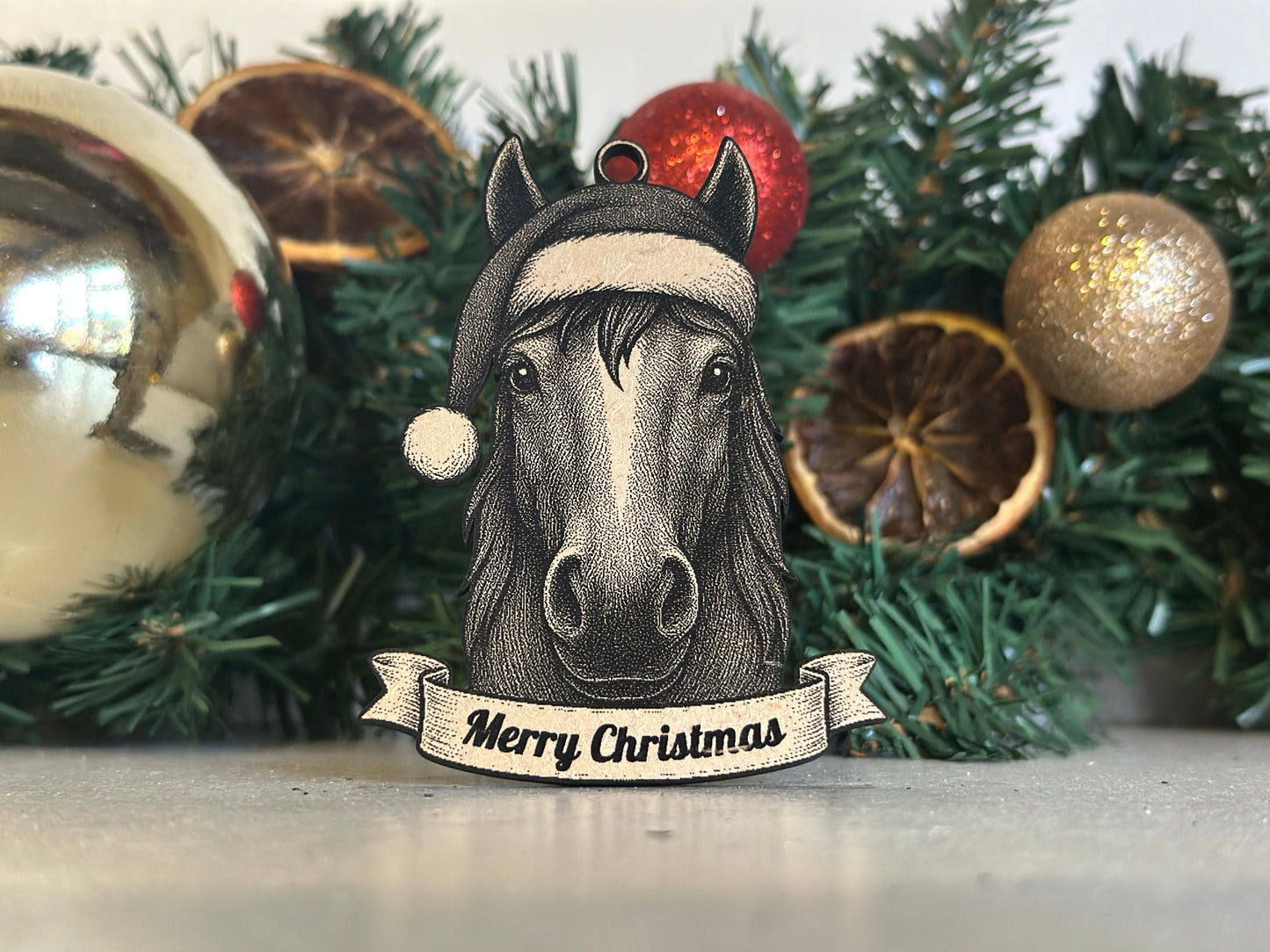 Decorative Christmas ornament with a Horse face and 'Merry Christmas' banner on a tree.