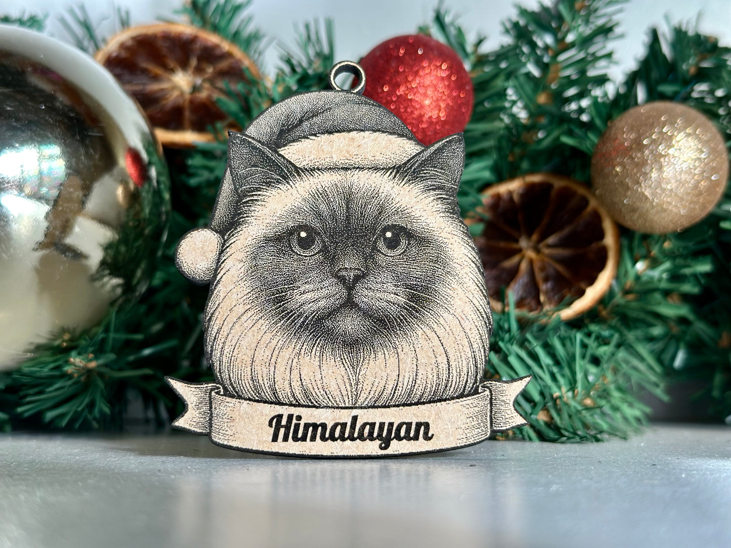 Cat ornament with 'Himalayan' label against a Christmas-themed background