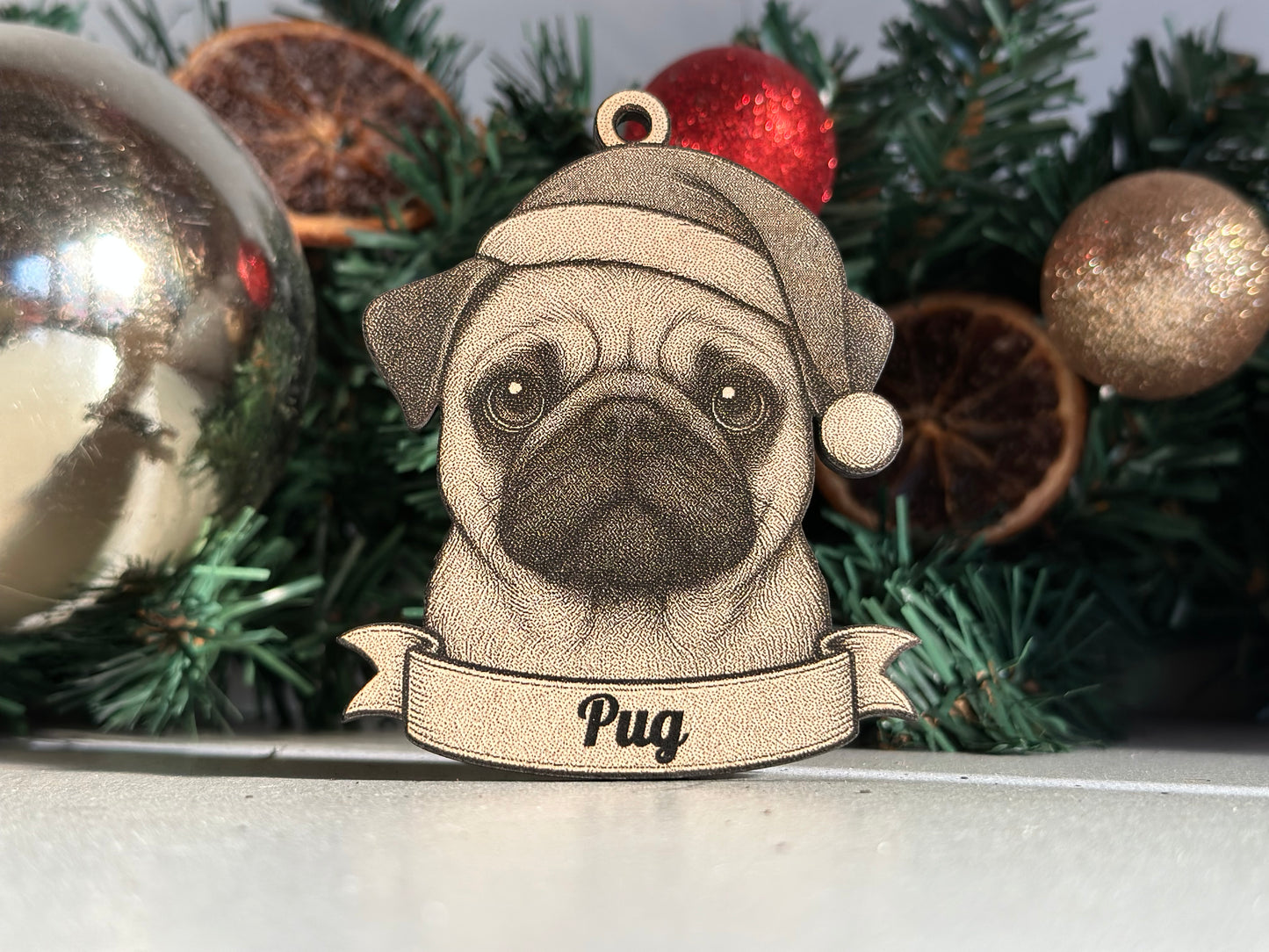 Decorative pug ornament with a banner on a Christmas tree.
