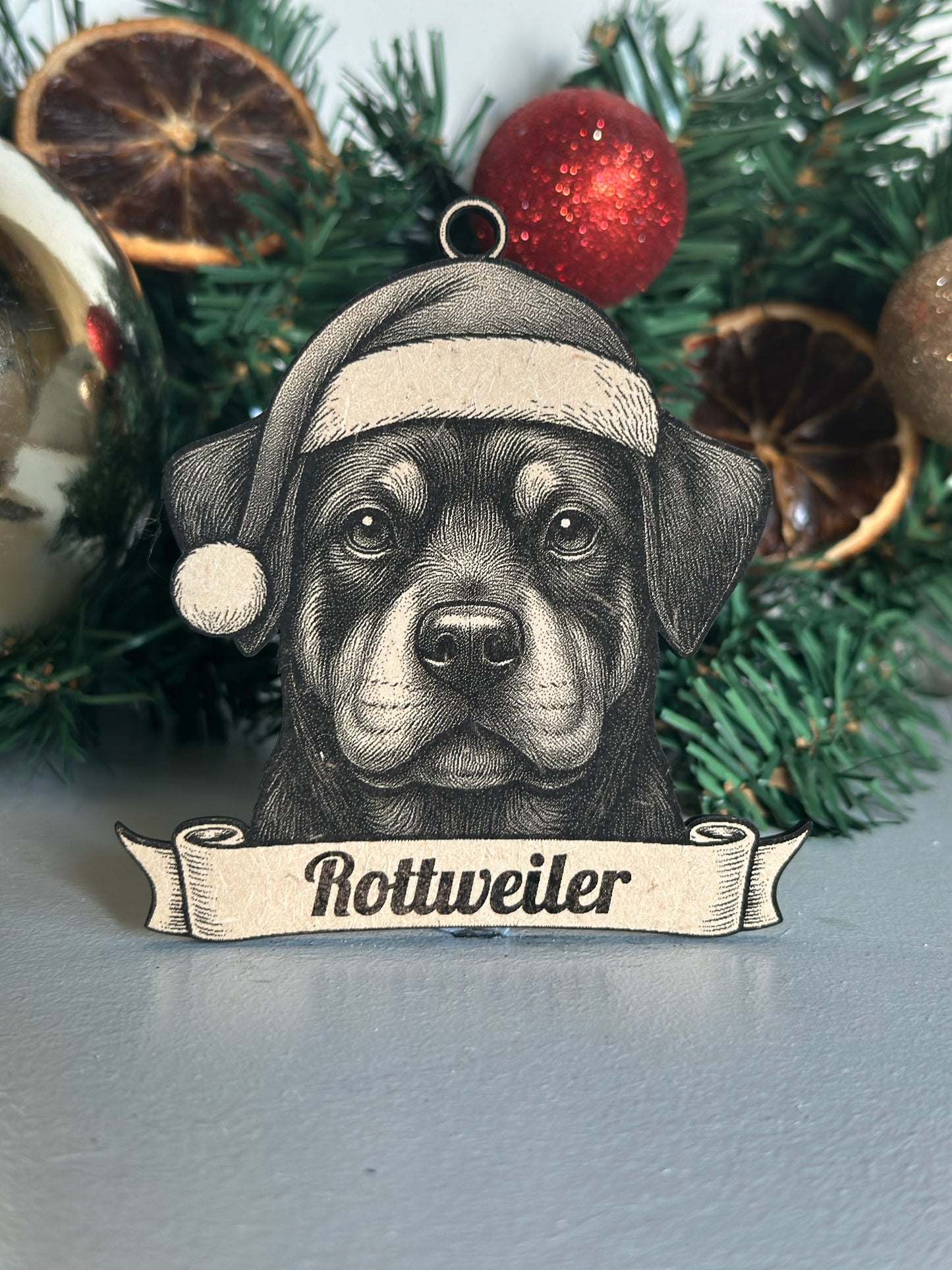Decorative Christmas ornament with a Rottweiler design on a Christmas tree.