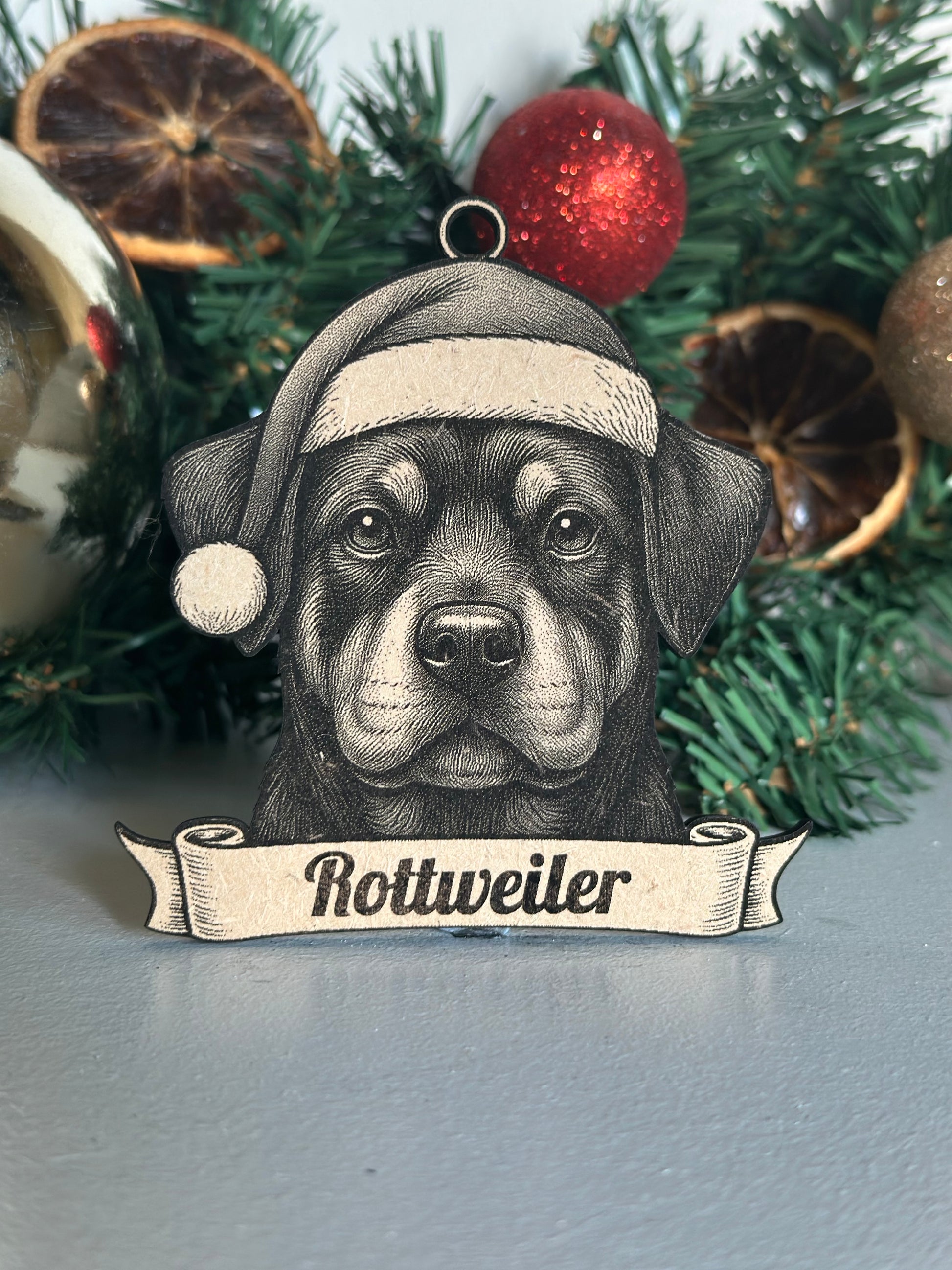 Decorative Christmas ornament with a Rottweiler design on a Christmas tree.