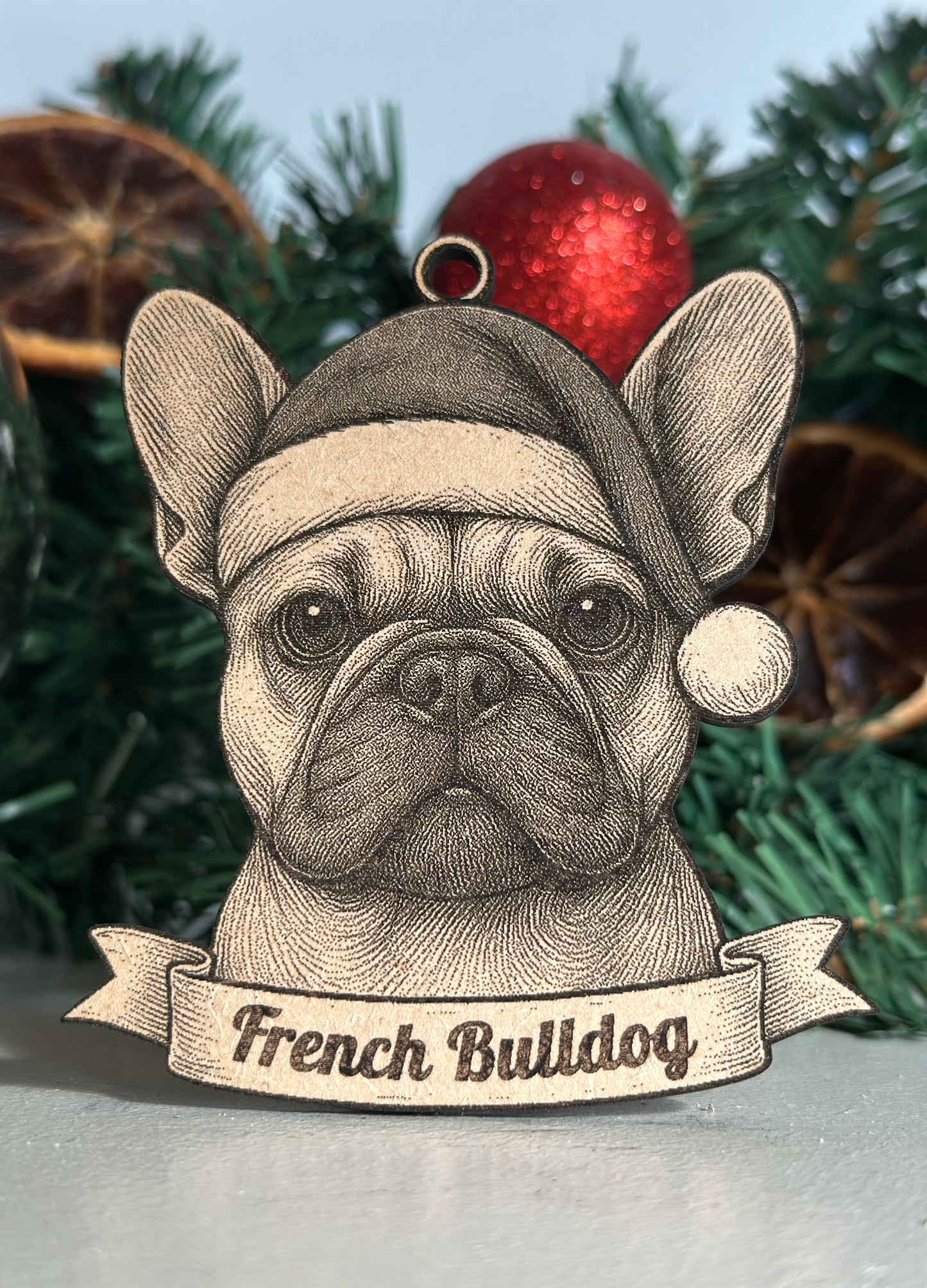Decorative Christmas ornament of a French Bulldog wearing a Santa hat with festive background.