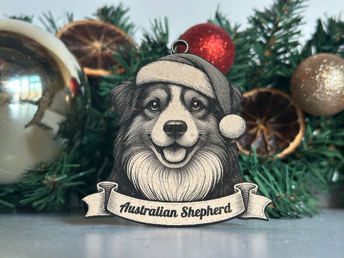 Decorative Christmas ornament with a dog illustration and Australian Shepherd text on a green wreath.