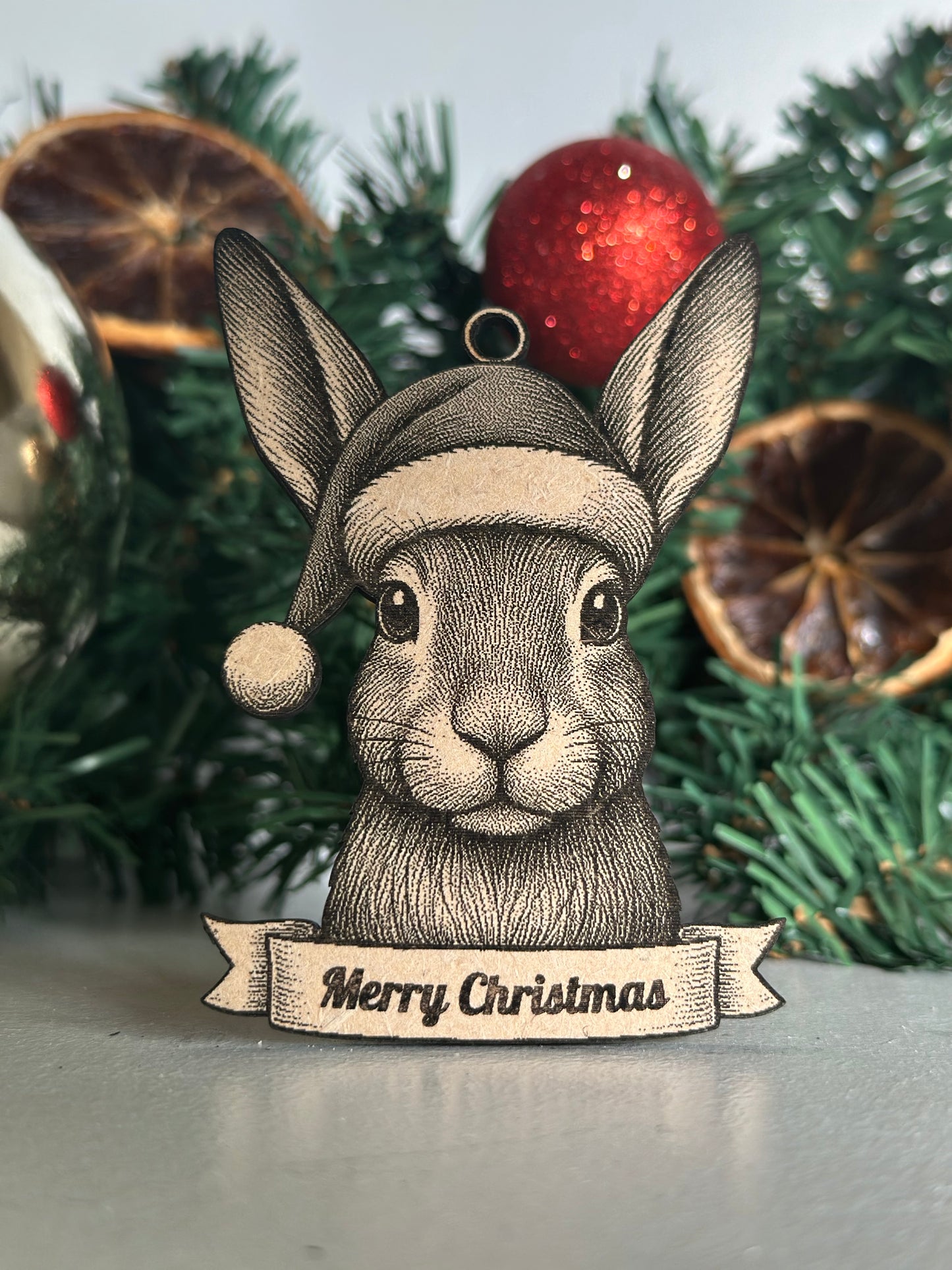 Decorative Christmas ornament with a Hare design and 'Merry Christmas' banner on a tree.
