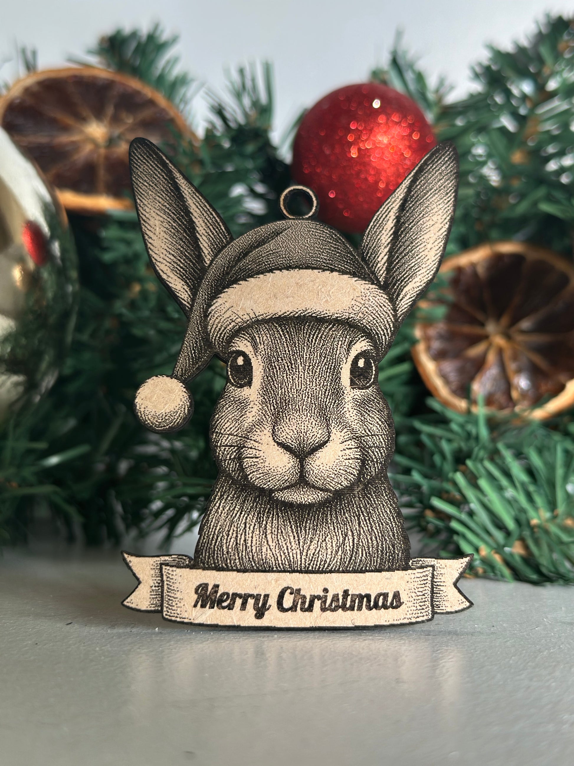 Decorative Christmas ornament with a Hare design and 'Merry Christmas' banner on a tree.
