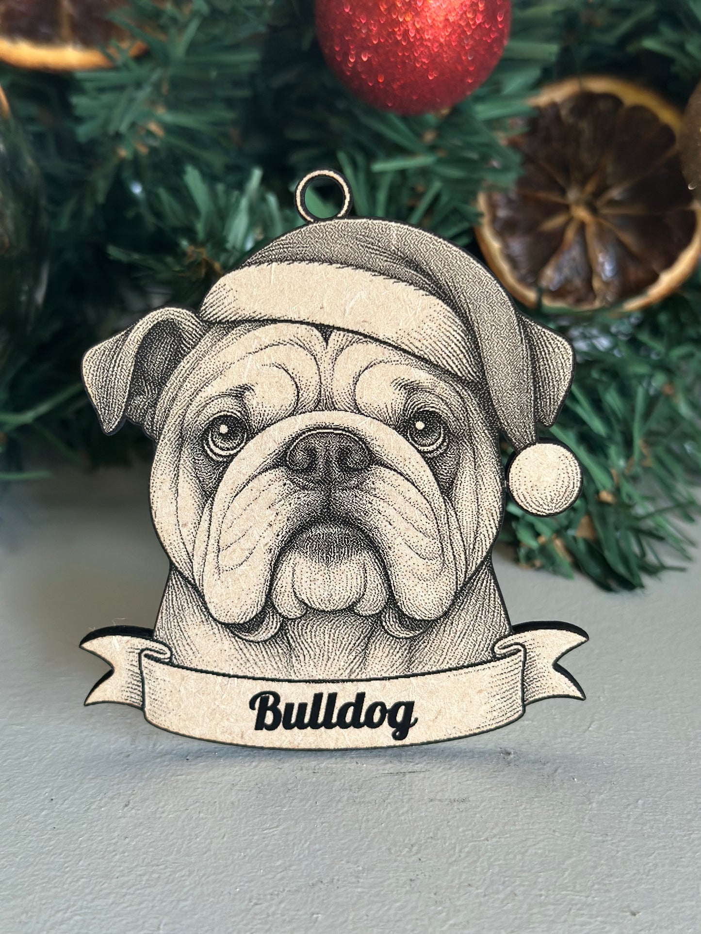 Decorative bulldog ornament with a banner on a Christmas tree.
