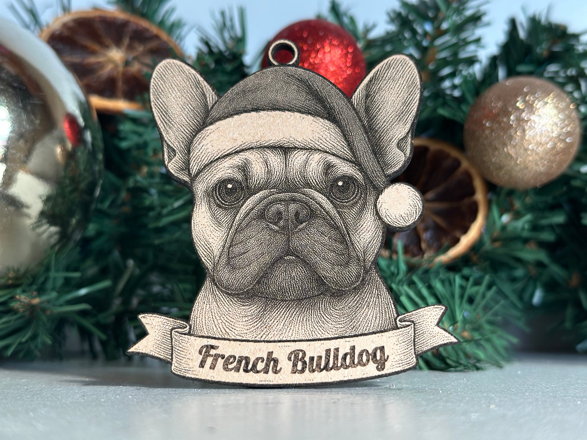 Decorative ornament of a French Bulldog with a banner on a Christmas tree.