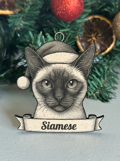 Decorative ornament of a Siamese cat with a banner on a Christmas tree.
