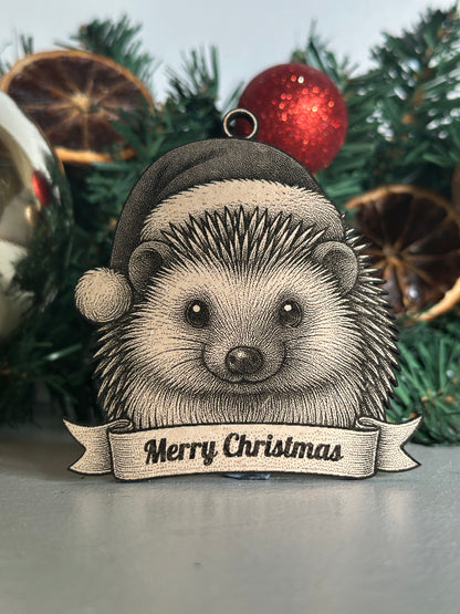 Decorative hedgehog ornament with 'Merry Christmas' banner on a Christmas tree.