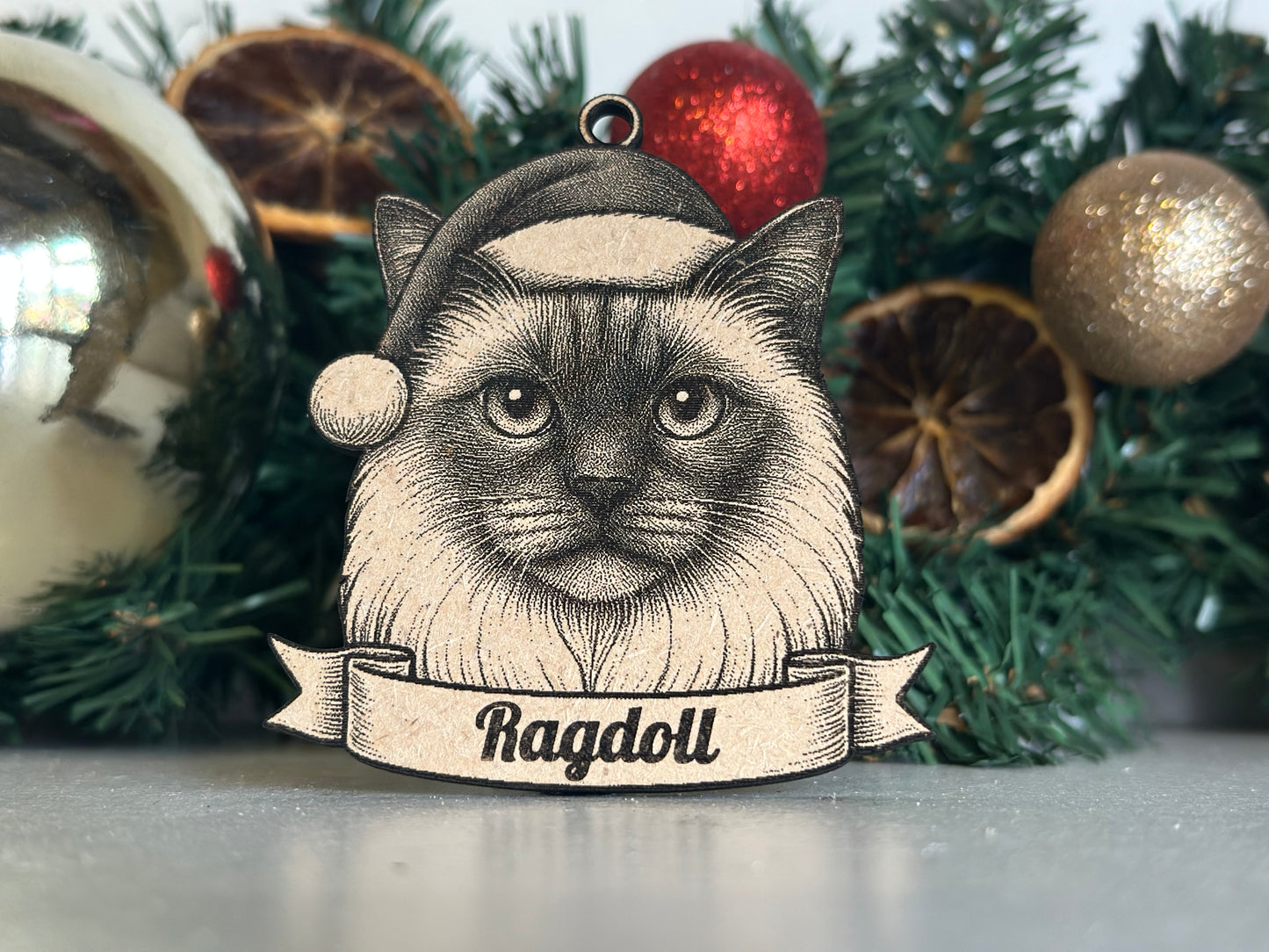 Decorative Christmas ornament with a dog illustration and 'Ragdoll' text on a tree.
