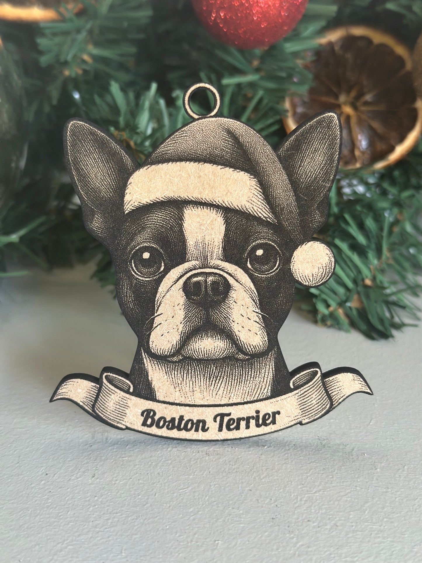 Decorative Christmas ornament with a Boston Terrier design on a tree.