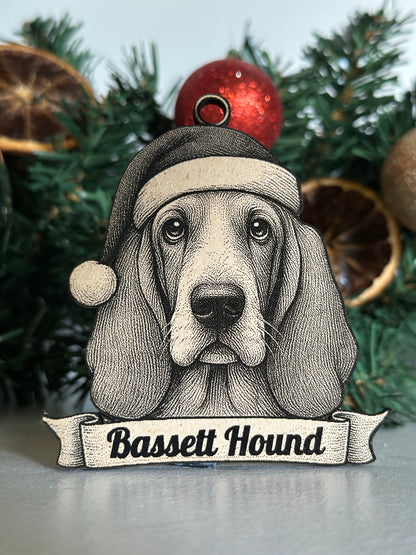 Decorative ornament of a Basset Hound with a sign on a Christmas tree.