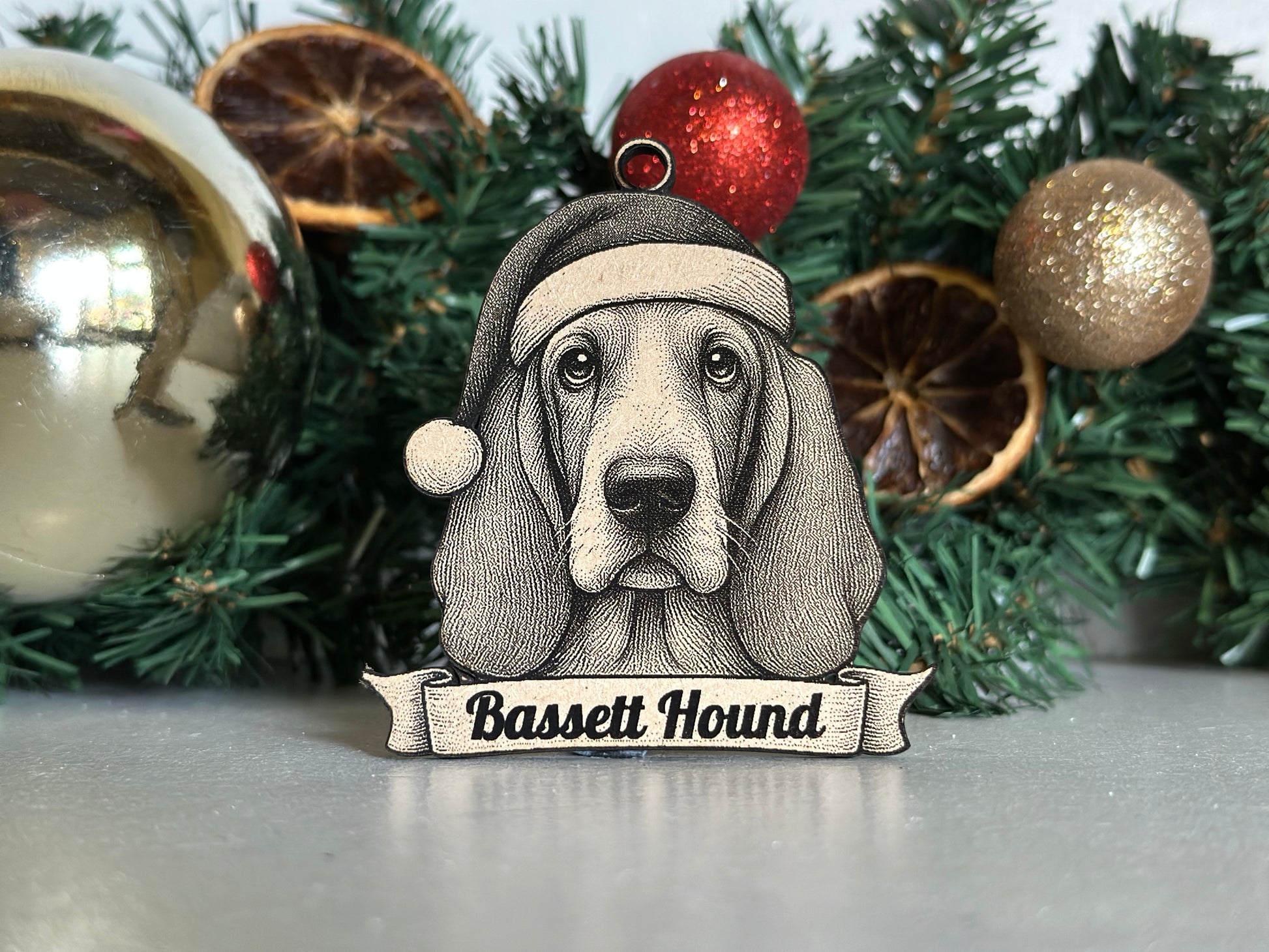 Decorative ornament with a basset hound design on a Christmas tree.