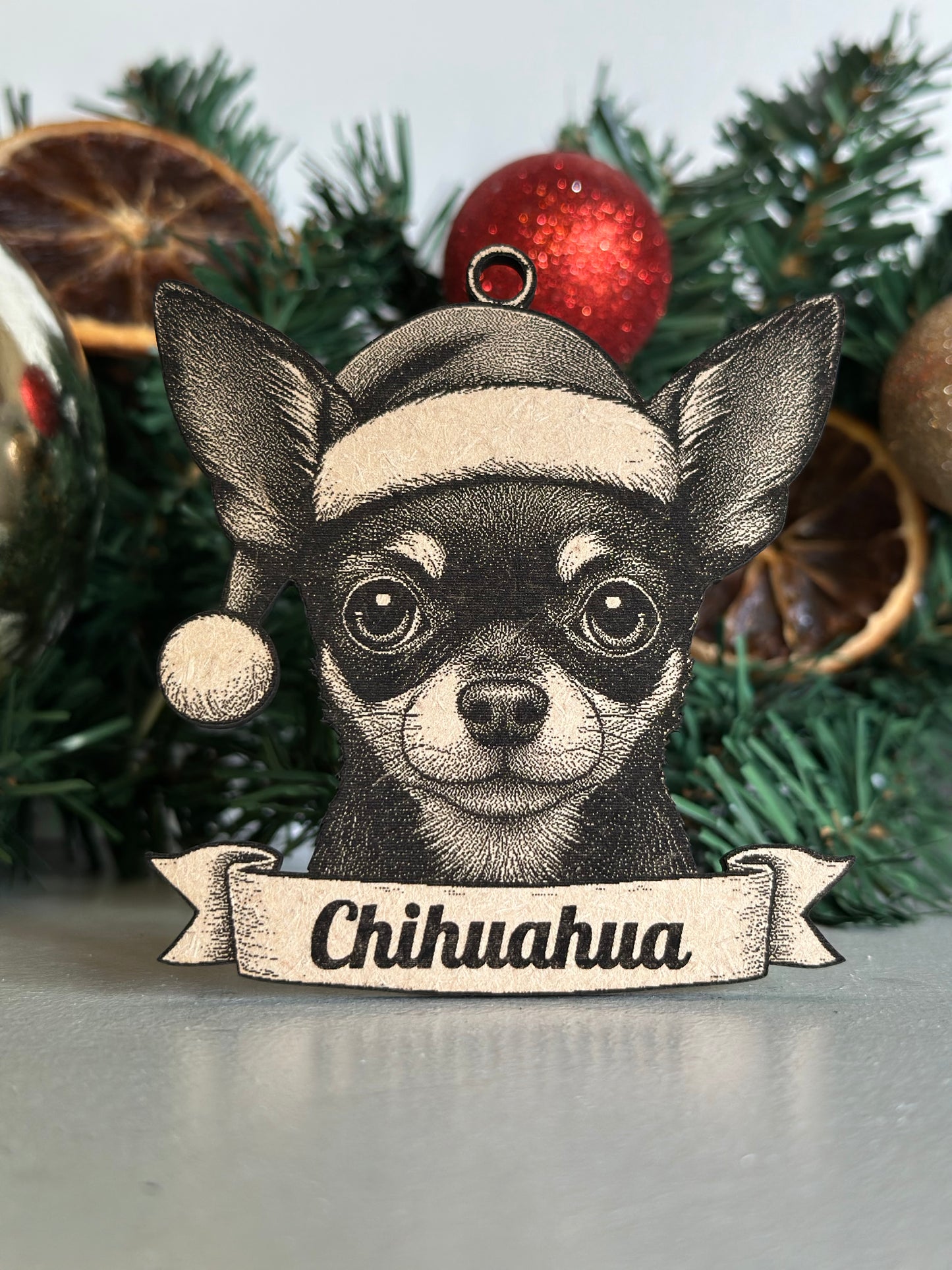 Decorative ornament of a Chihuahua dog with a banner on a Christmas tree.