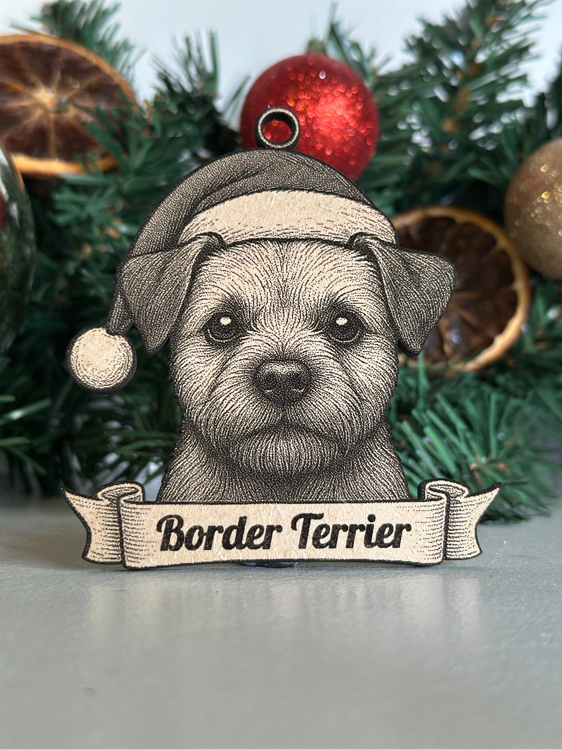 Ornament with a border terrier design on a Christmas tree.