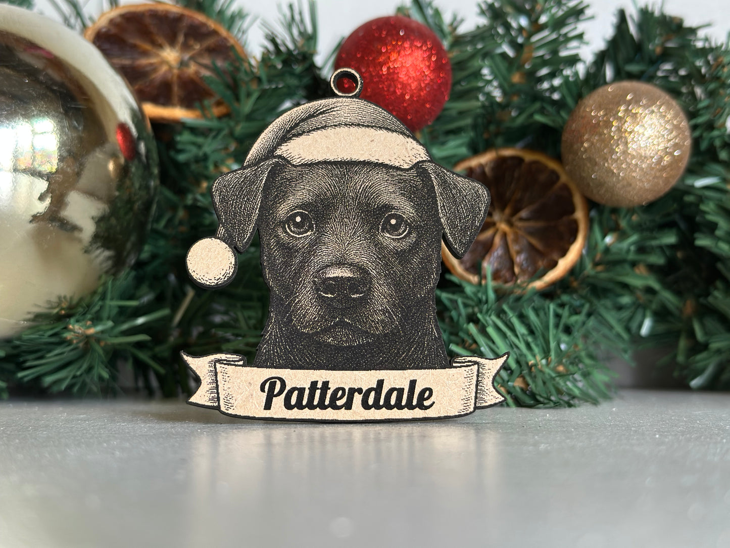 Decorative ornament with a dog illustration and 'Patterdale' text on a Christmas wreath.