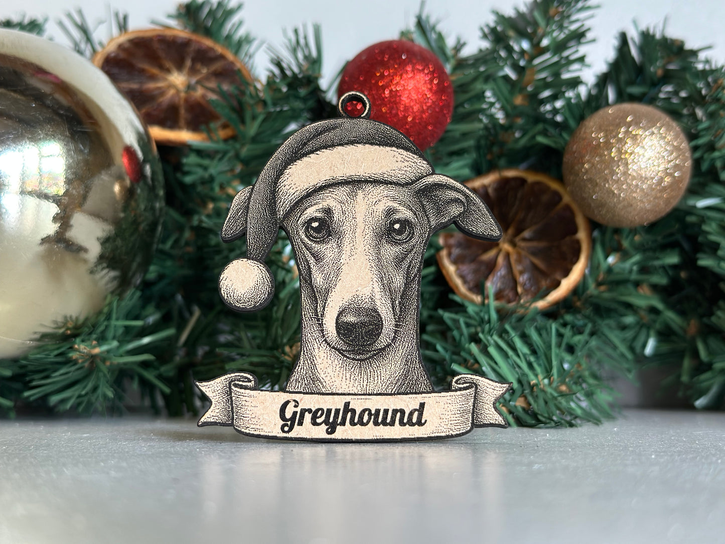 Decorative reindeer ornament with 'Greyhound' text on a Christmas tree.