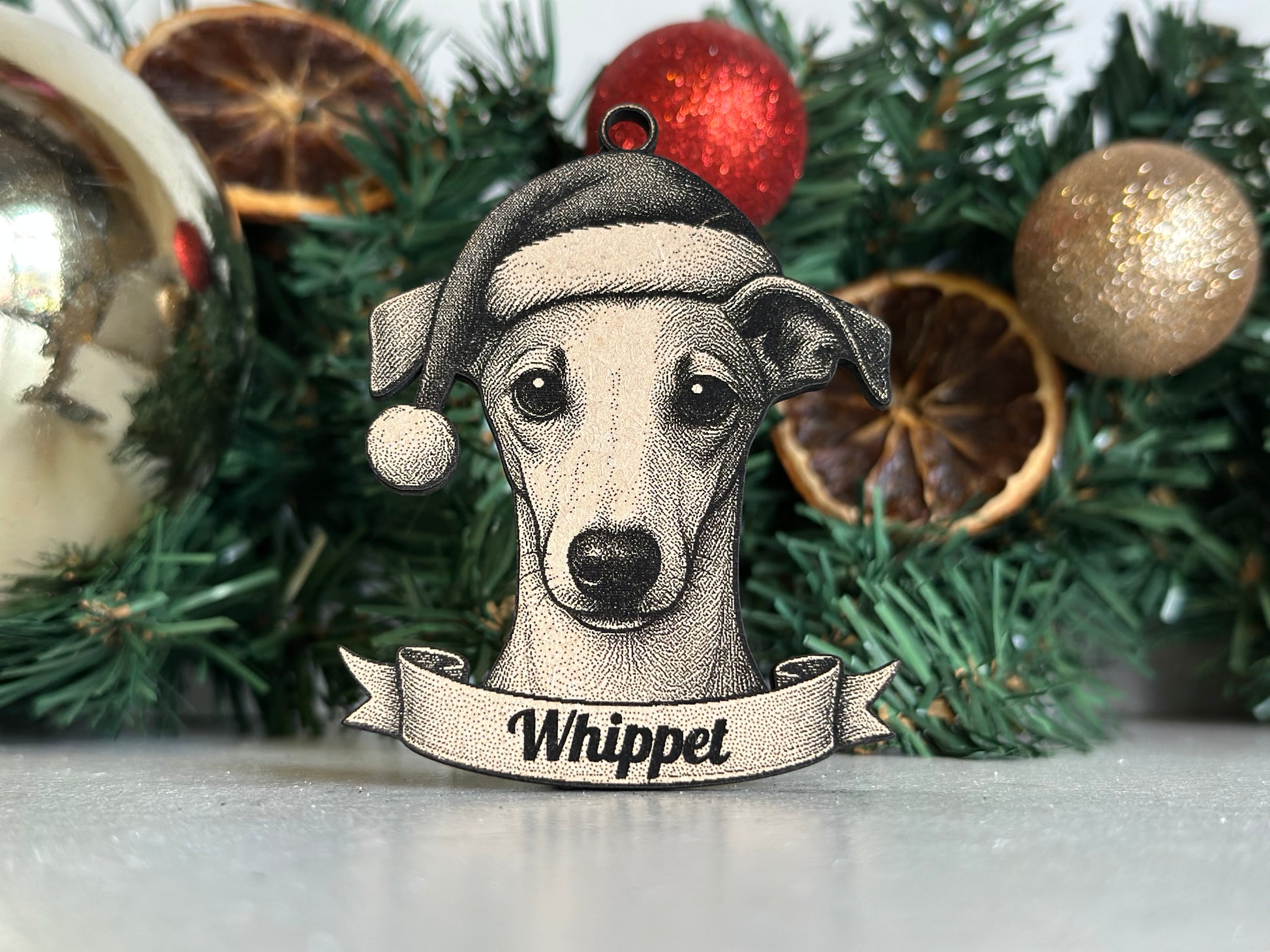 Decorative dog ornament with 'Whippet' on a Christmas tree.
