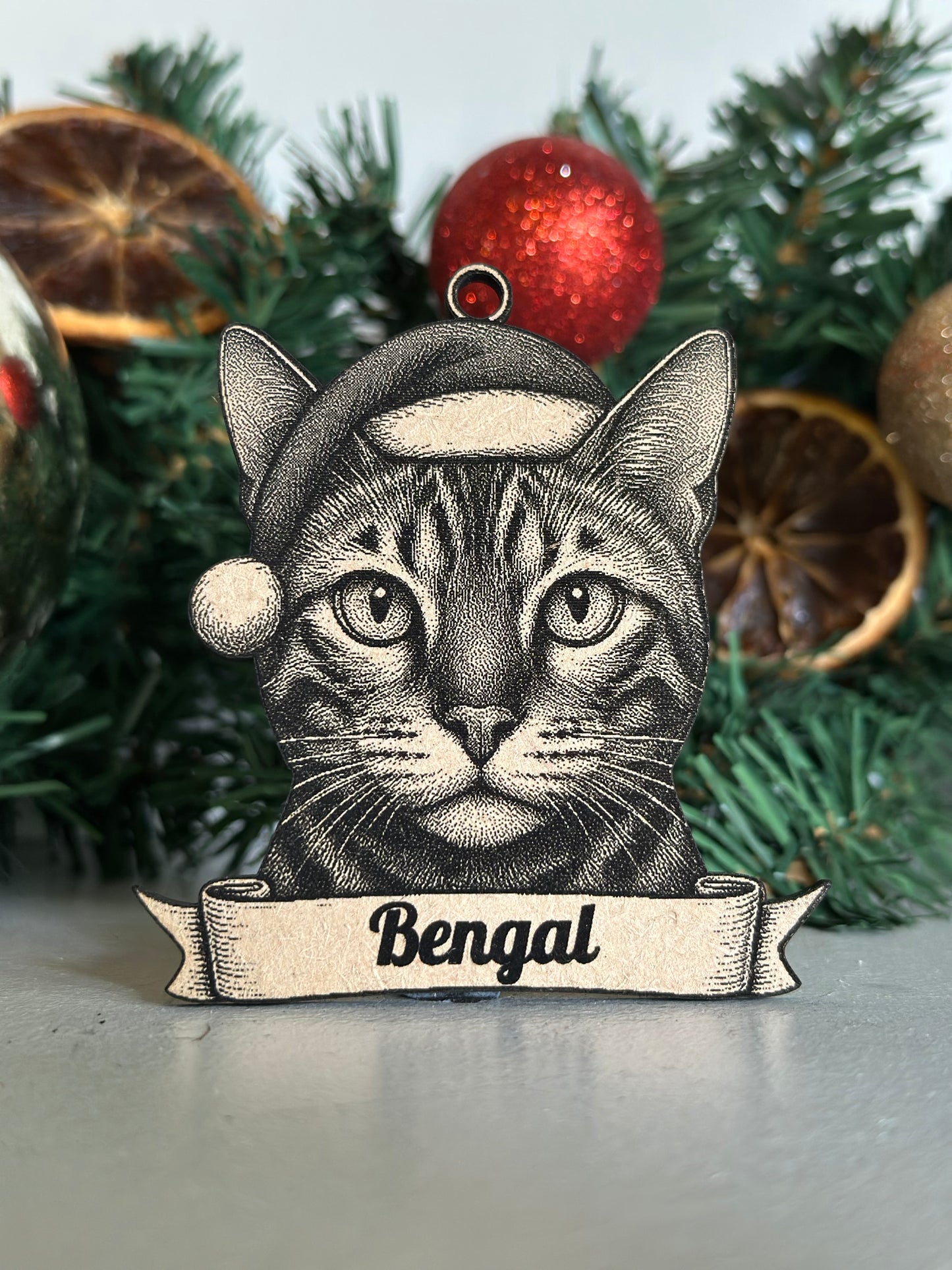 Decorative ornament with a bengal cat design on a Christmas tree.