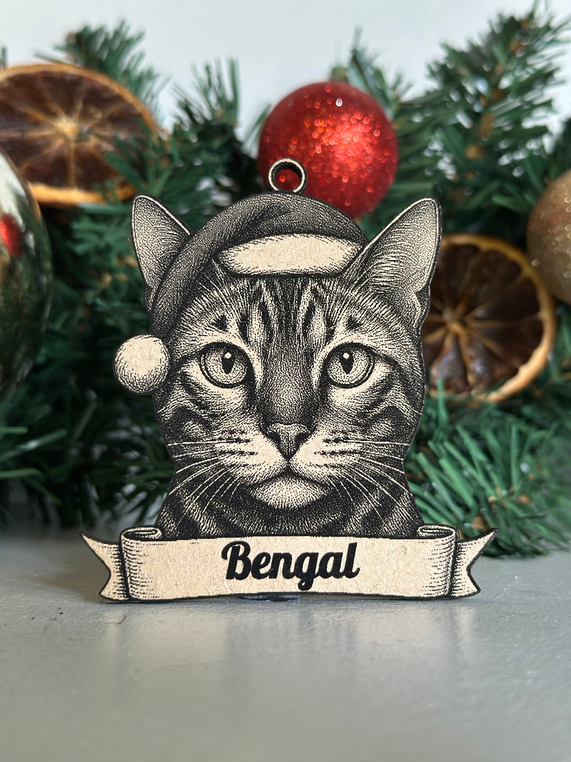 Decorative ornament with a bengal cat design on a Christmas tree.