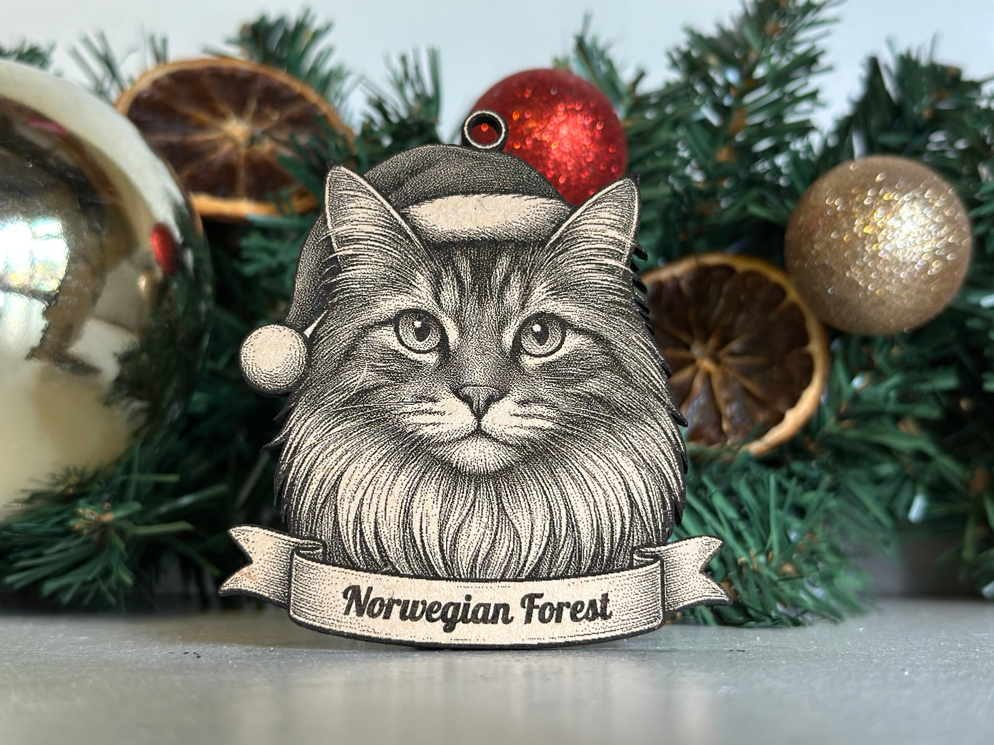 Decorative Christmas ornament with a cat's face and 'Norwegian Forest' text on a green wreath.