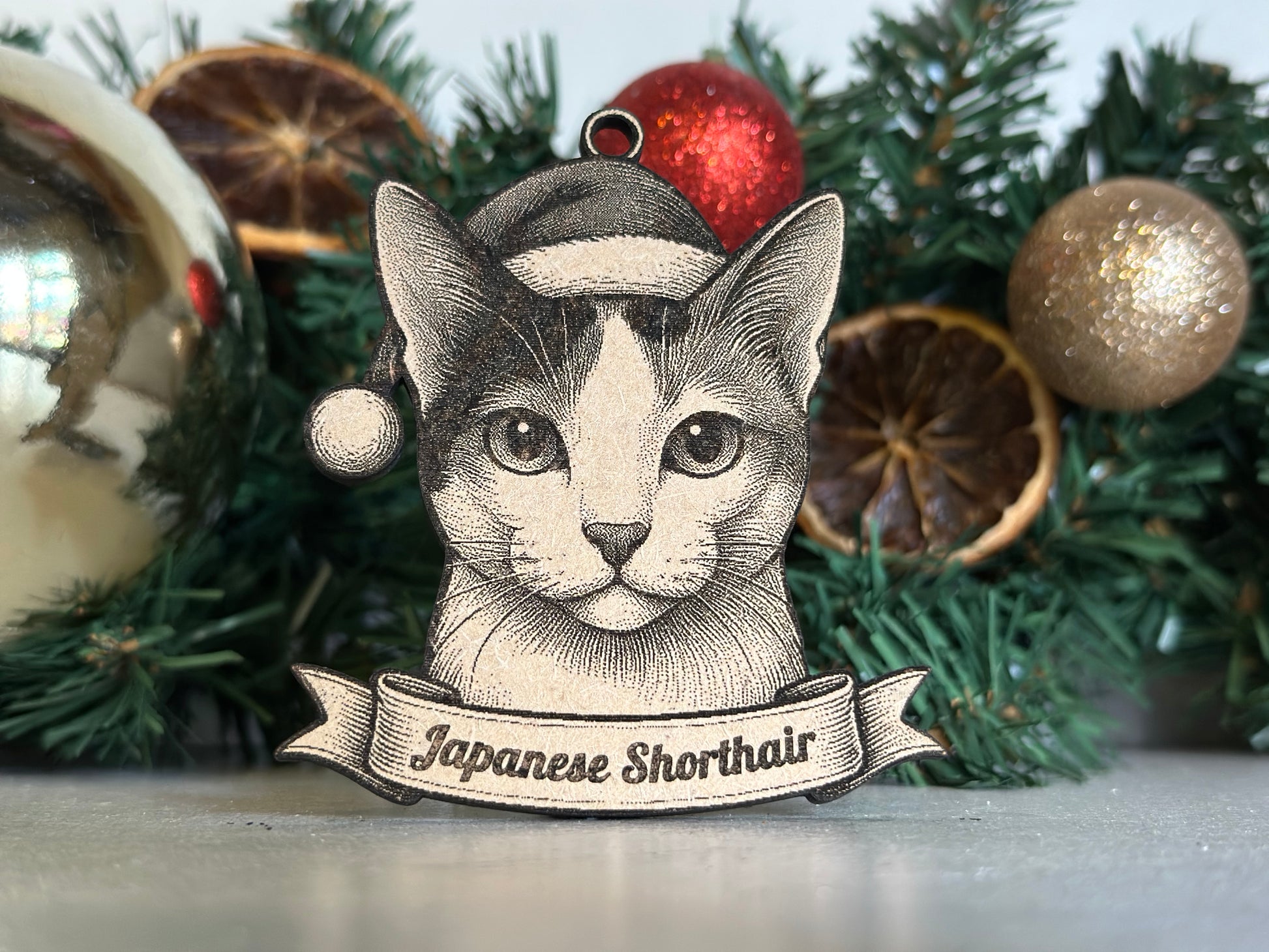 Decorative Christmas ornament with a Japanese Shorthair illustration on a green wreath.