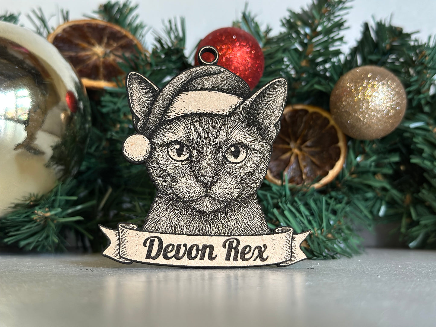 Decorative ornament with a Devon Rex cat illustration on a Christmas wreath.