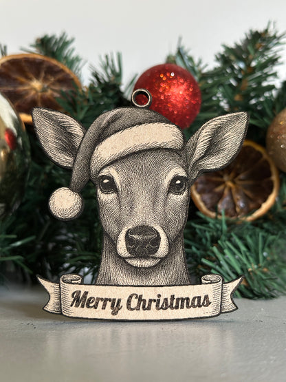 Decorative der / doe ornament with 'Merry Christmas' banner on a Christmas tree.