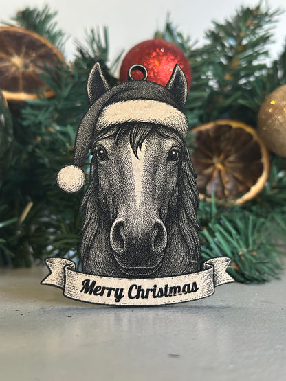 Decorative horse ornament with 'Merry Christmas' banner on a Christmas tree.