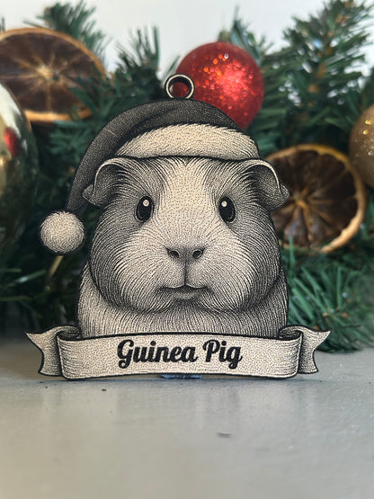 Decorative ornament of a guinea pig with a sign on a Christmas tree.