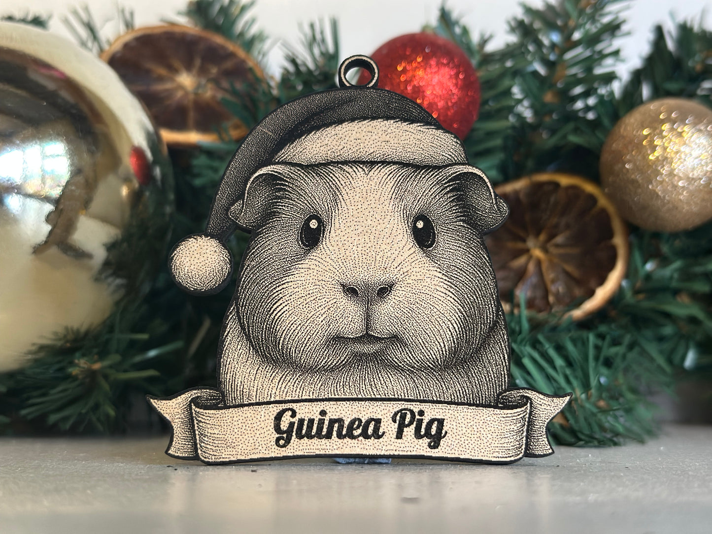 Decorative ornament of a guinea pig with a sign on a Christmas decoration