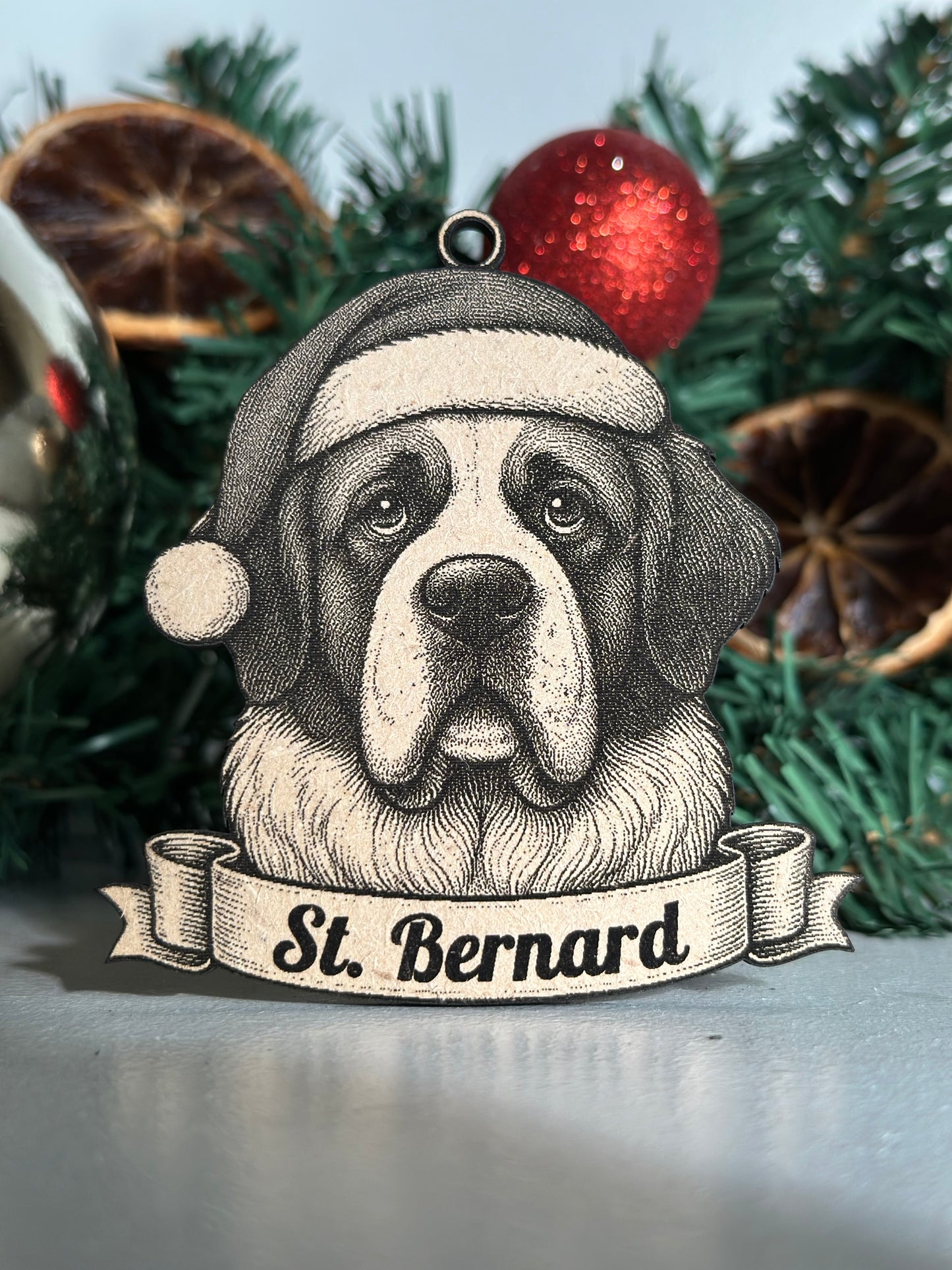 St. Bernard dog ornament on a Christmas tree with a red ball and green branches.