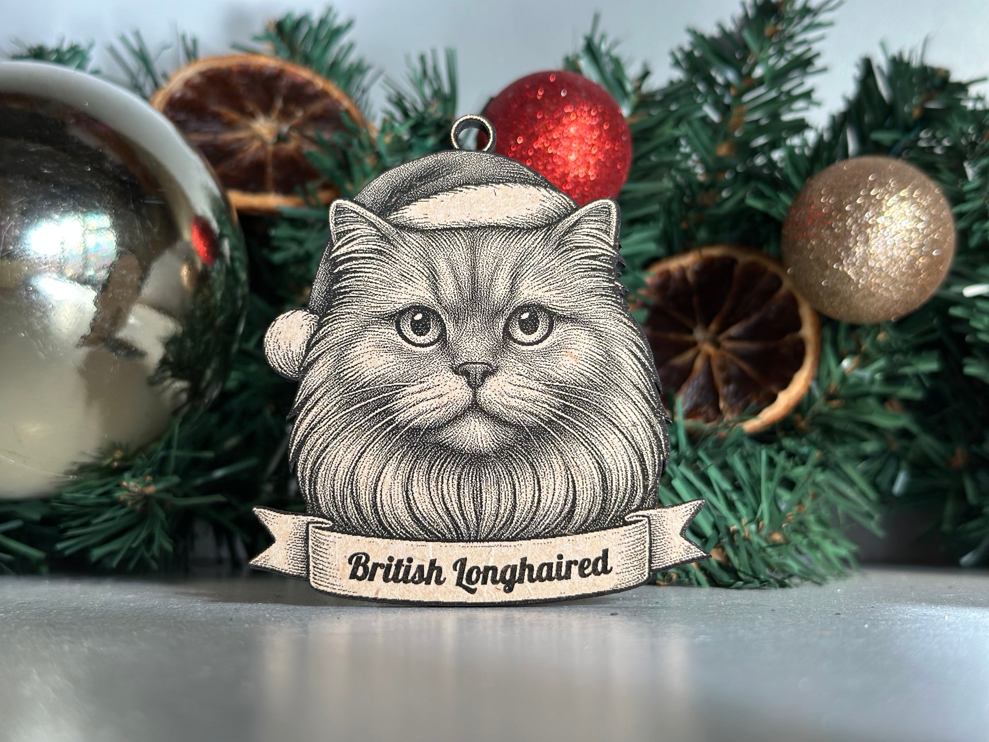 Decorative Christmas british longhaired cat decoration with a vintage-style face design on a green wreath with ornaments.
