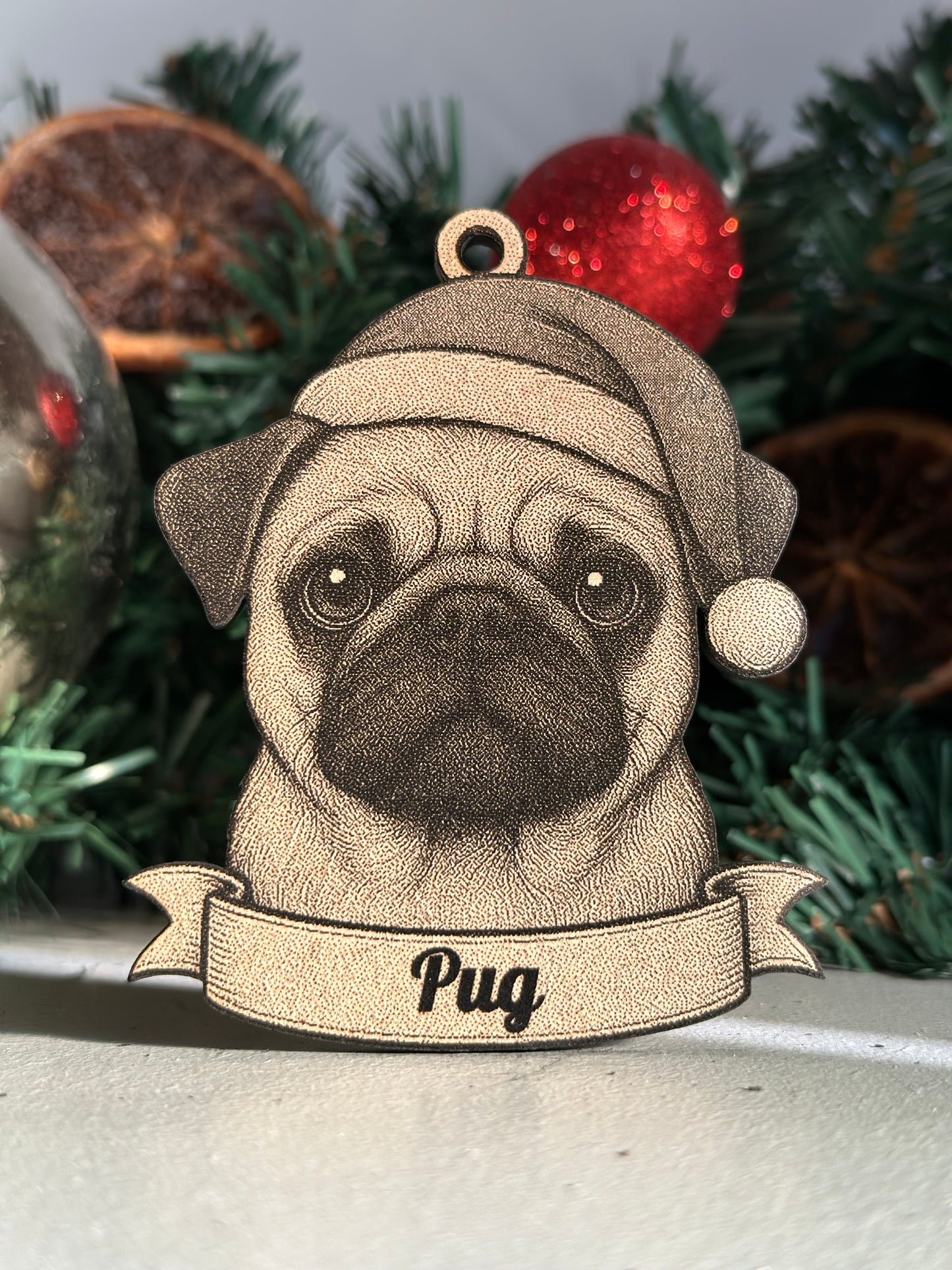 Wooden pug ornament with a banner on a Christmas tree.
