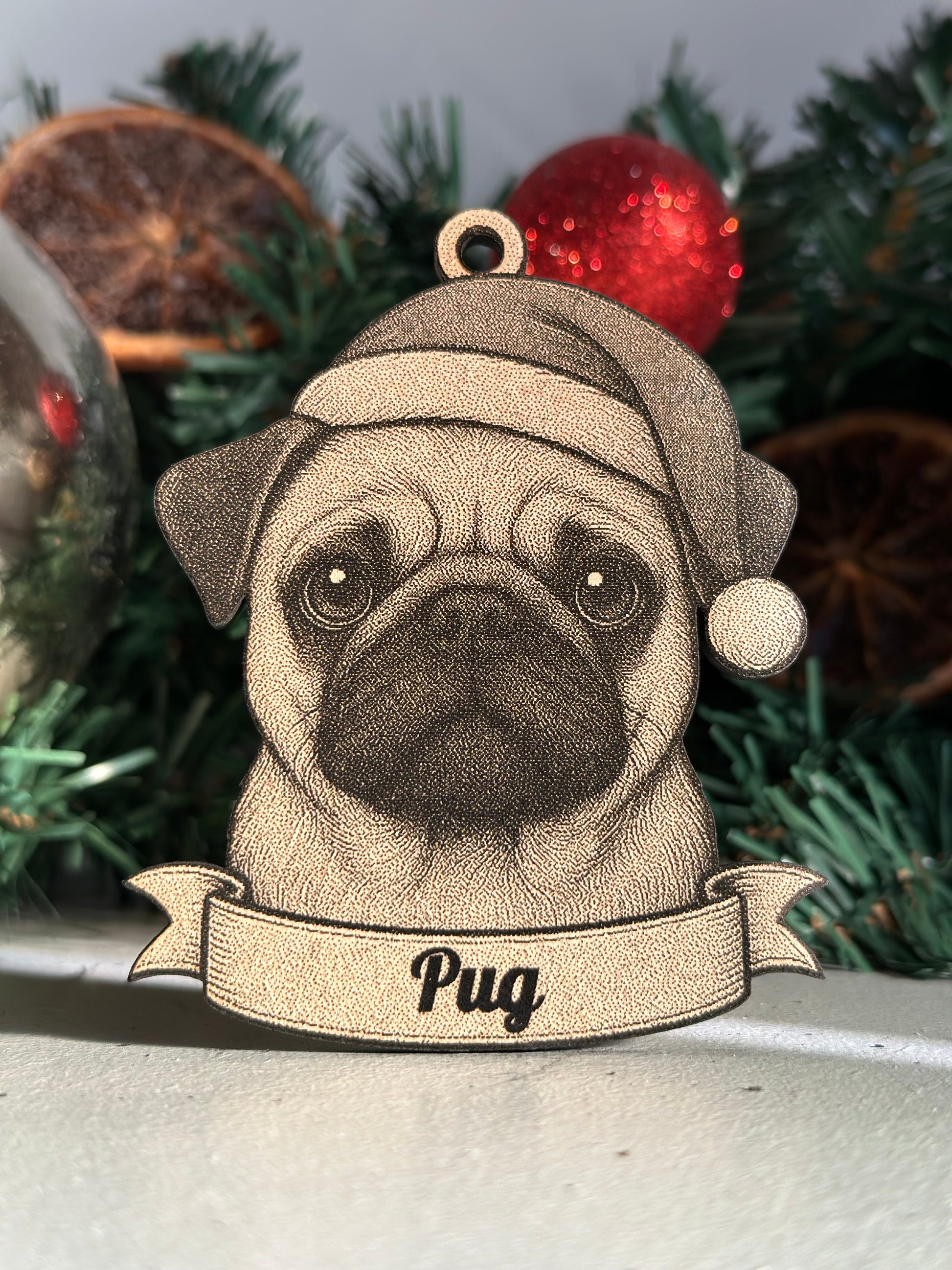 Wooden pug ornament with a banner on a Christmas tree.