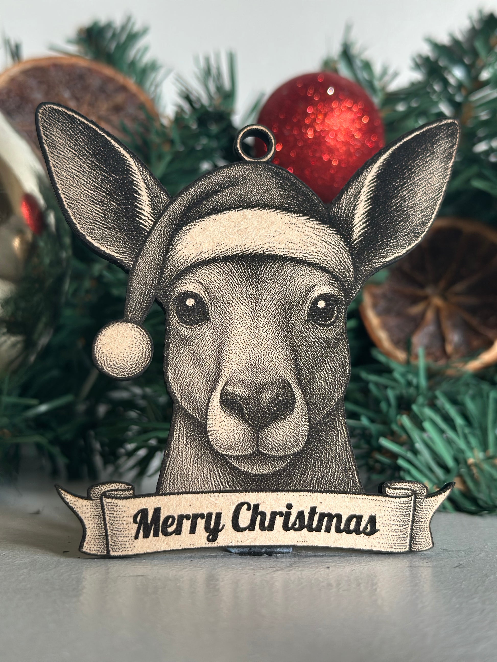Decorative kangaroo ornament with 'Merry Christmas' tag on a Christmas tree.
