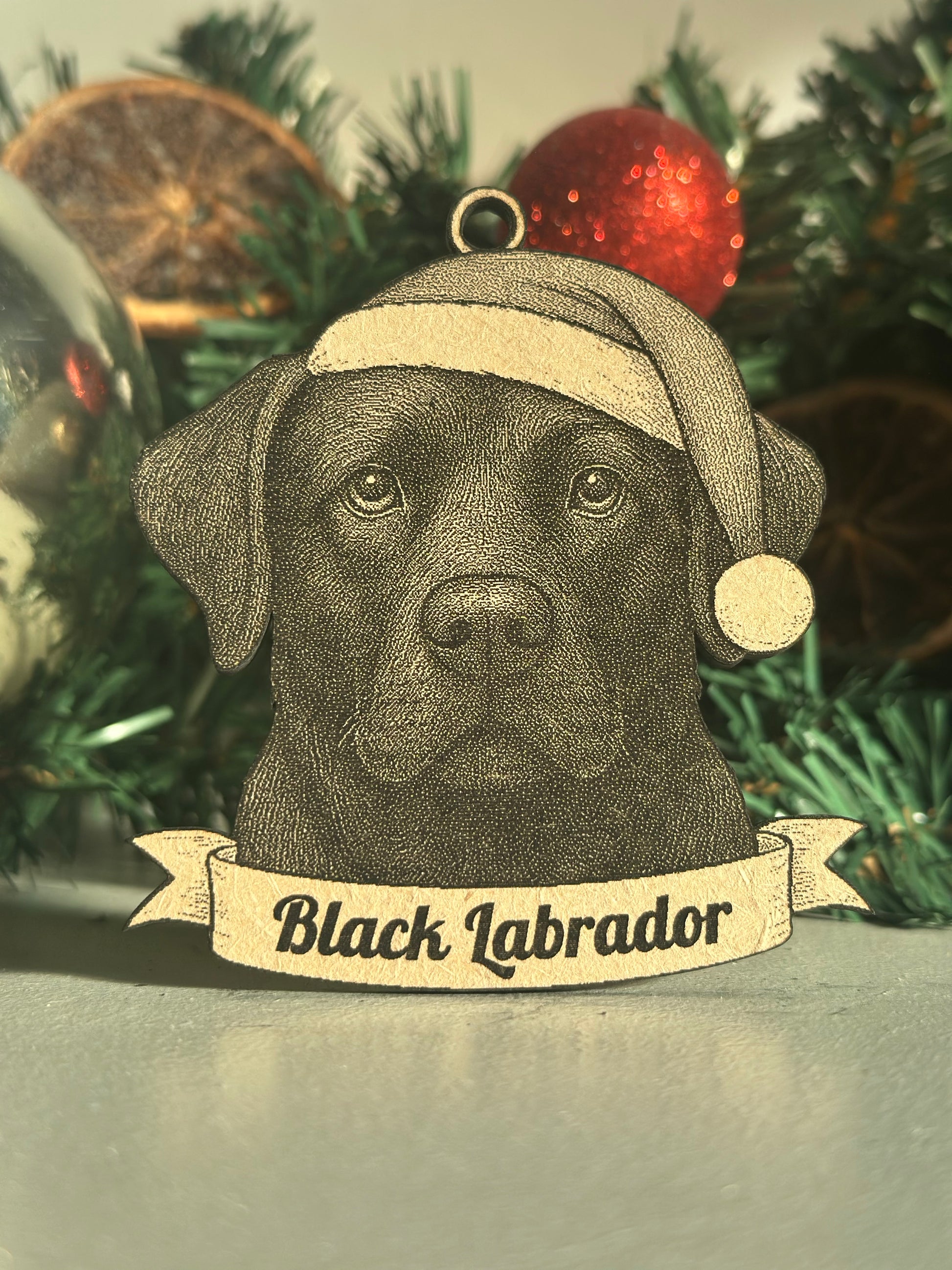 Black Labrador ornament on a Christmas tree with a label
