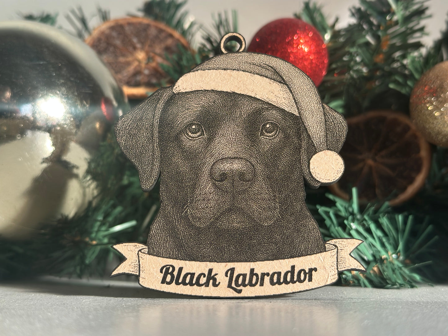 Black Labrador Christmas ornament on a decorated tree with a banner reading 'Black Labrador'.