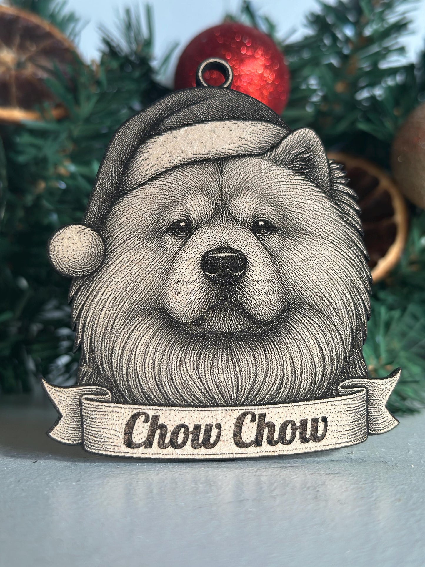 Decorative ornament with a Chow Chow dog design and 'Chow Chow' text against a Christmas tree background.