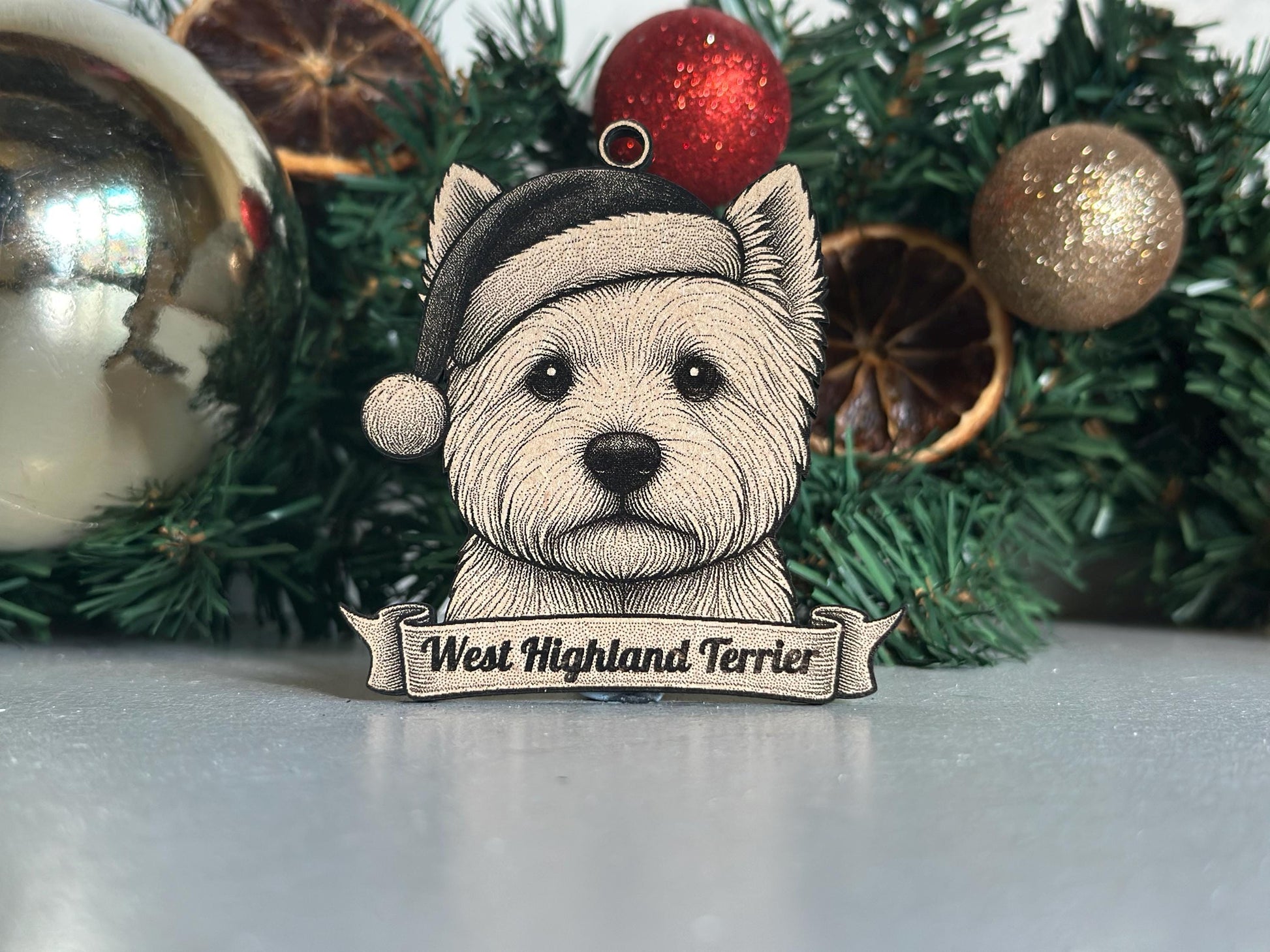 West Highland Terrier ornament with a Santa hat in front of Christmas decorations