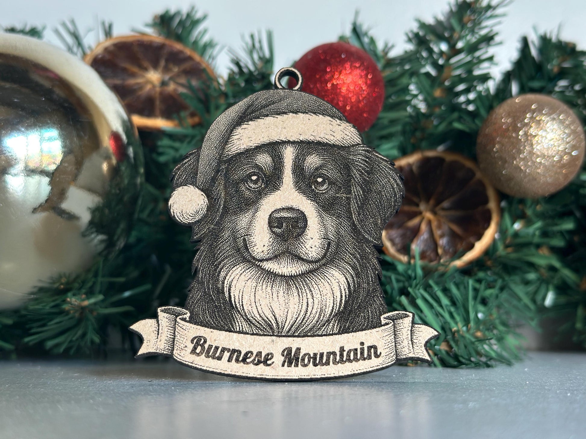 Dog ornament with 'Bernese Mountain' text in front of Christmas decorations